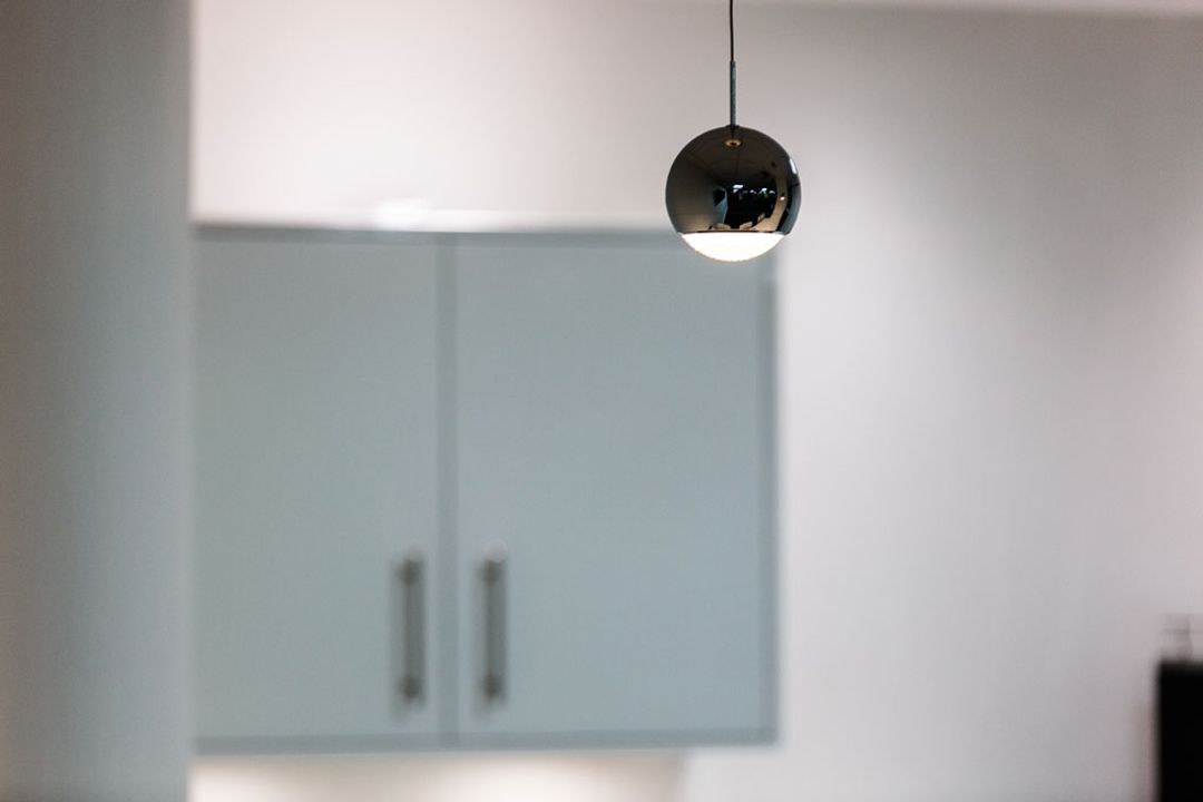 Polished chrome designer pendant lights hanging above
                    the breakout bar at Premier Group, Manchester