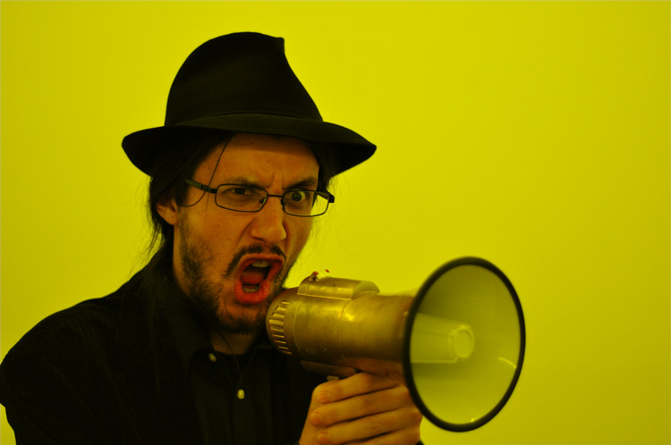 A bearded man shouting through a megaphone - (Photo by Very
                Quiet)