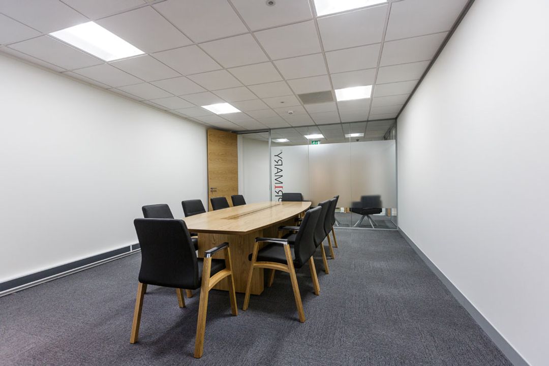 Primary Capital Boardroom with branded glass partition
                    wall complete with Sven oak veneer table and Fulcrum F1
                    chairs
